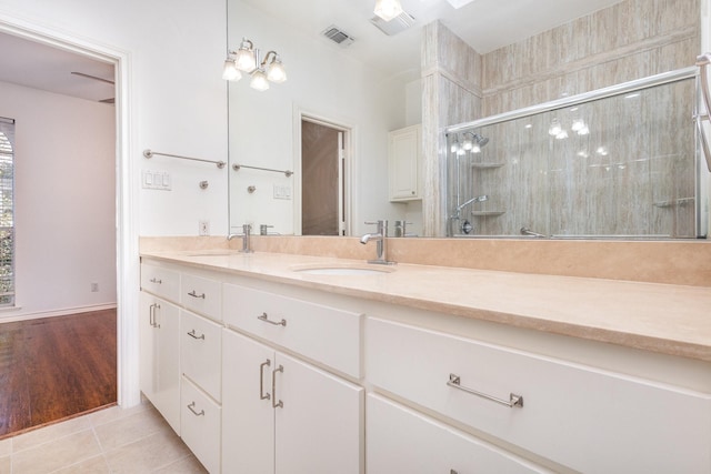 bathroom featuring tile patterned flooring, vanity, and a shower with shower door