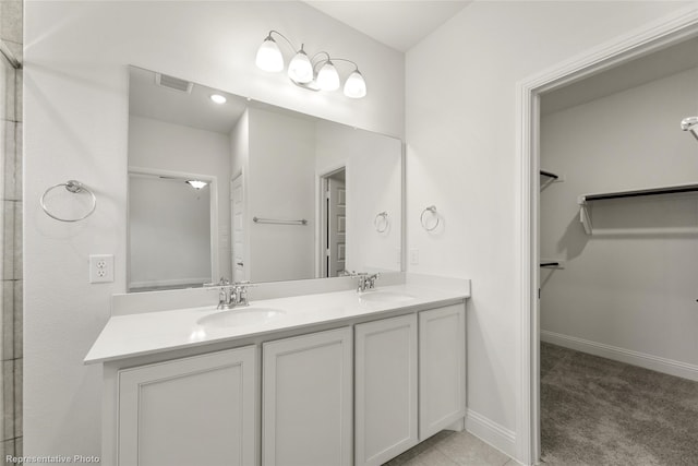 full bathroom featuring a spacious closet, a sink, visible vents, and double vanity