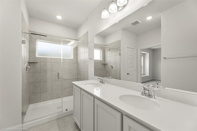 bathroom with visible vents, tile patterned flooring, a stall shower, and a sink