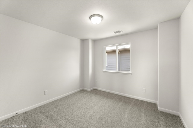 carpeted empty room featuring baseboards and visible vents