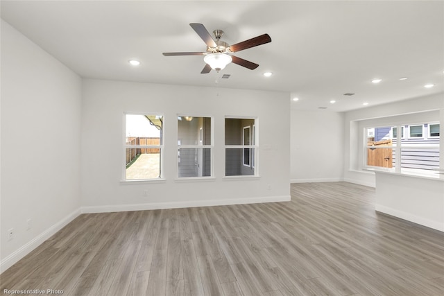 unfurnished living room with ceiling fan and light hardwood / wood-style flooring