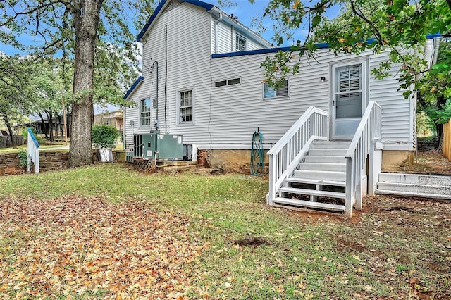 rear view of house featuring a lawn