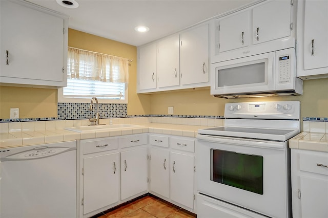 kitchen featuring tile countertops, white cabinets, white appliances, and light tile patterned floors