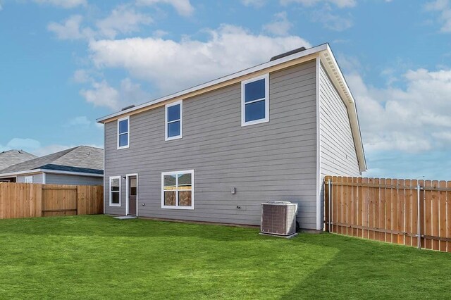 rear view of property with a lawn and cooling unit