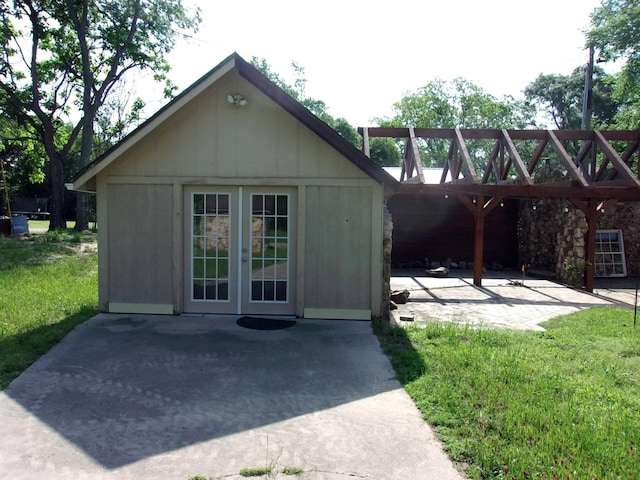 view of outdoor structure featuring a yard and french doors