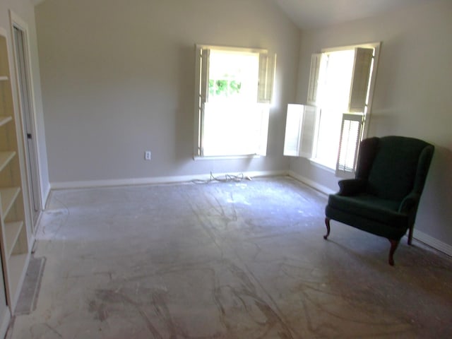 unfurnished room with lofted ceiling and a healthy amount of sunlight