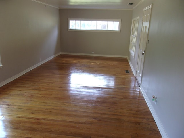 empty room with crown molding and dark wood-type flooring