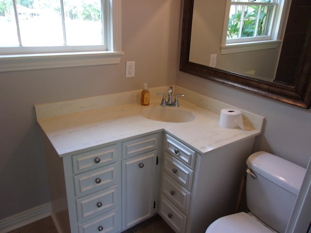 bathroom featuring a healthy amount of sunlight, vanity, and toilet