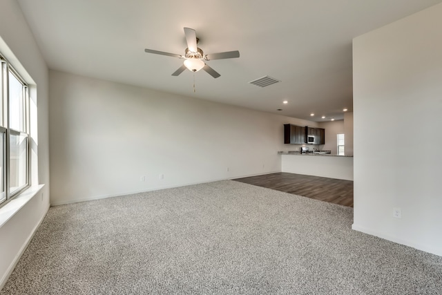 unfurnished living room with carpet flooring and ceiling fan