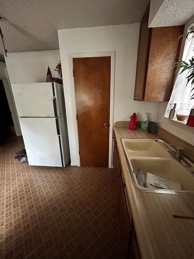 1721 Cooper Dr, Irving, TX 75061 - kitchen with a sink, freestanding refrigerator, and a textured ceiling