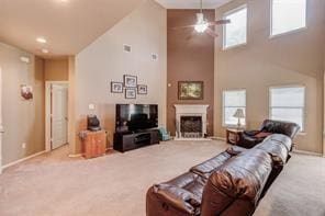 carpeted living room with ceiling fan and high vaulted ceiling