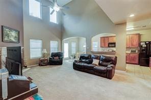 living room with a high ceiling, carpet floors, and ceiling fan