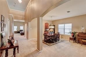 carpeted dining area featuring a chandelier