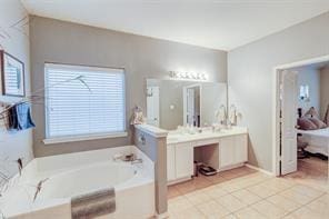 bathroom with tile patterned flooring, vanity, and a washtub