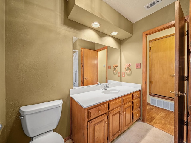 bathroom featuring vanity, tile patterned floors, and toilet