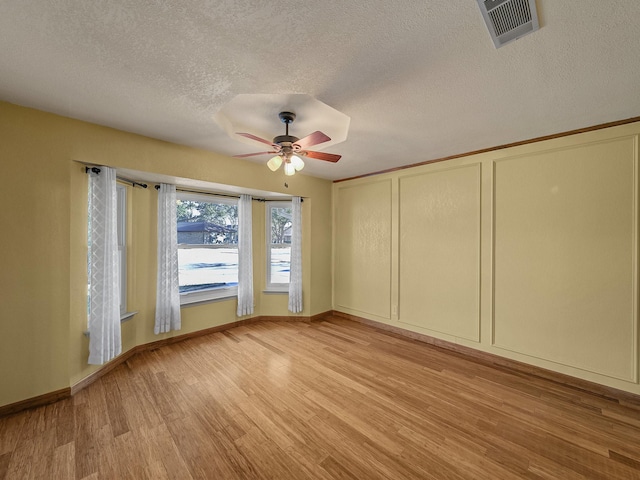 spare room with ceiling fan, a textured ceiling, and light hardwood / wood-style flooring