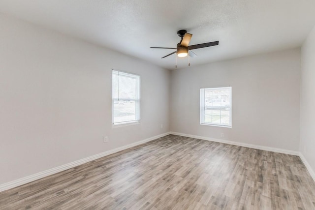 spare room featuring ceiling fan, light hardwood / wood-style floors, and a textured ceiling