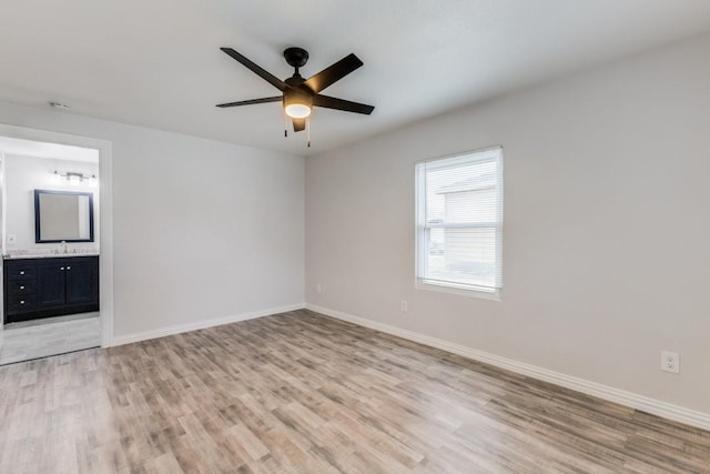 unfurnished bedroom with ceiling fan, light hardwood / wood-style floors, sink, and connected bathroom