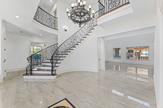 entryway featuring a towering ceiling and crown molding