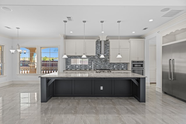 kitchen featuring light stone countertops, white cabinetry, an island with sink, and appliances with stainless steel finishes