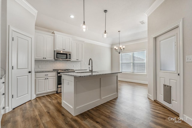 kitchen featuring a center island with sink, sink, hanging light fixtures, white cabinetry, and stainless steel appliances