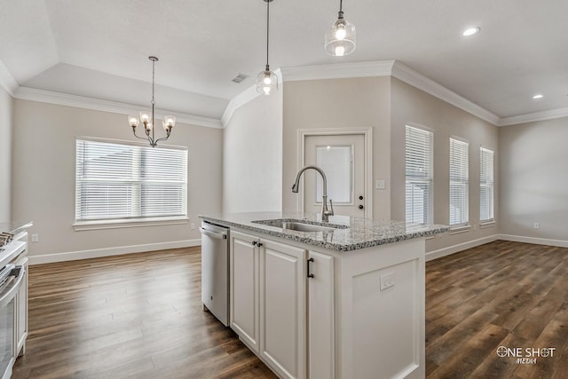 kitchen featuring a center island with sink, sink, hanging light fixtures, stainless steel dishwasher, and light stone countertops