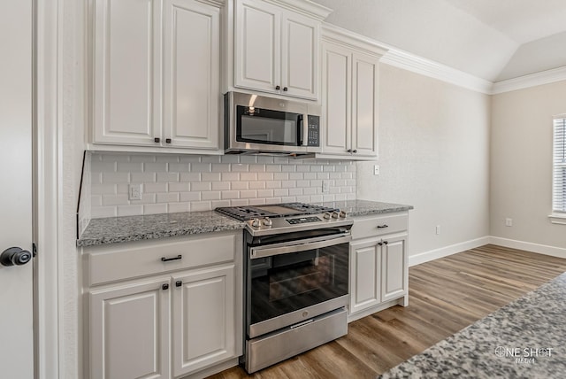 kitchen with white cabinetry, light stone countertops, light hardwood / wood-style floors, and appliances with stainless steel finishes