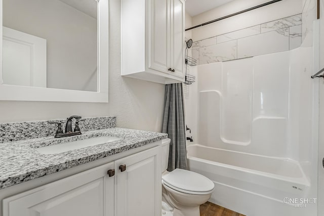 full bathroom featuring hardwood / wood-style flooring, shower / tub combo with curtain, vanity, and toilet