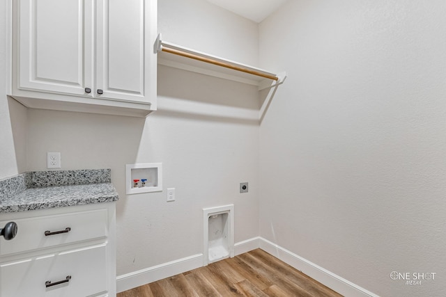 clothes washing area with cabinets, hookup for a washing machine, light hardwood / wood-style flooring, and electric dryer hookup