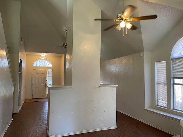 entryway featuring dark wood-type flooring, ceiling fan, lofted ceiling, and a textured ceiling