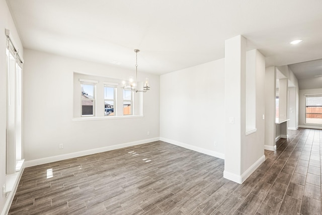 unfurnished dining area featuring dark wood-type flooring and a chandelier