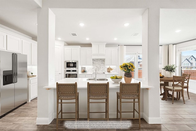 kitchen featuring tasteful backsplash, a kitchen bar, stainless steel fridge with ice dispenser, and white cabinets