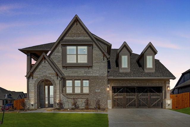 view of front of property featuring a garage and a lawn