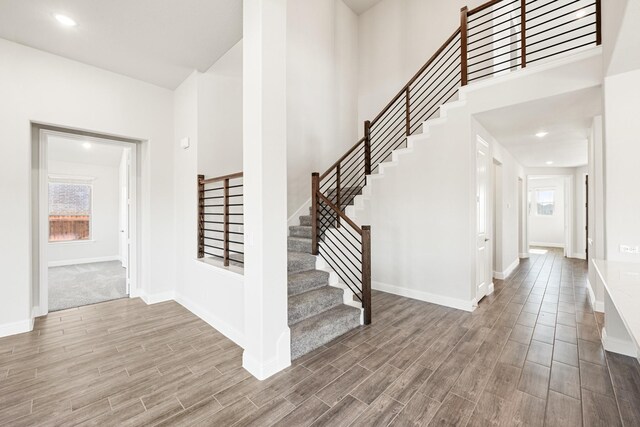 foyer featuring a towering ceiling and wood-type flooring