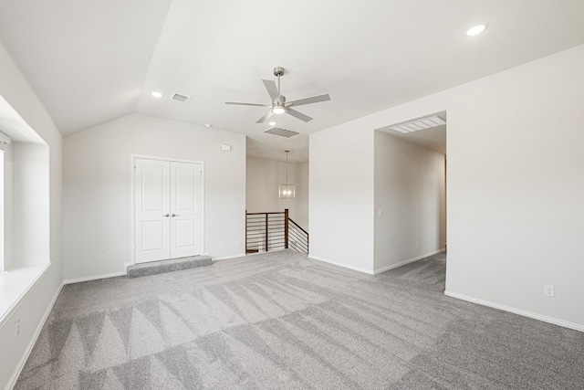 carpeted empty room featuring vaulted ceiling and ceiling fan