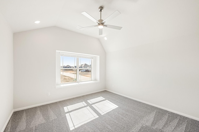 empty room with carpet floors, vaulted ceiling, and ceiling fan