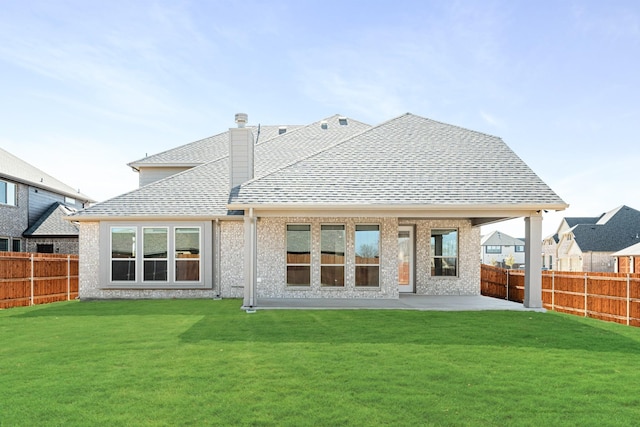 back of property with a yard and a patio area