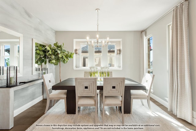 dining area with wood-type flooring, a wealth of natural light, and an inviting chandelier