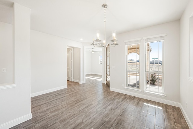 unfurnished dining area with hardwood / wood-style flooring and a notable chandelier