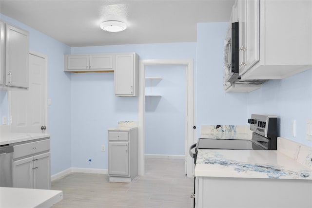 kitchen with stove, white cabinets, and stainless steel dishwasher