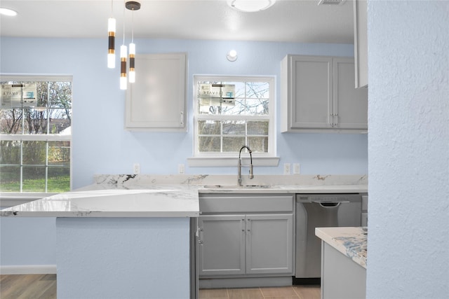 kitchen featuring a healthy amount of sunlight, sink, decorative light fixtures, dishwasher, and gray cabinets