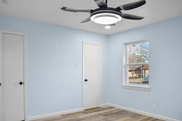 unfurnished room with light wood-type flooring and ceiling fan