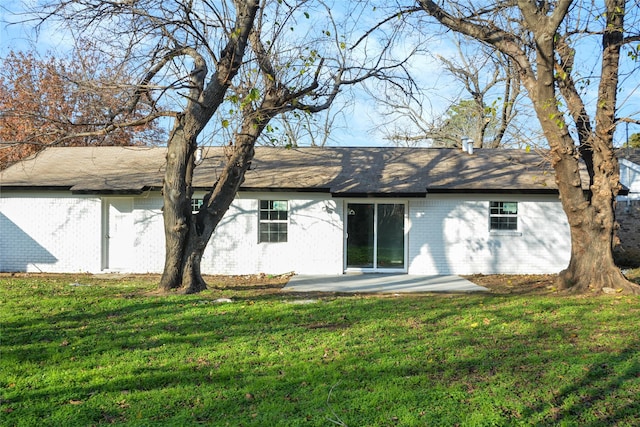 back of property featuring a lawn and a patio