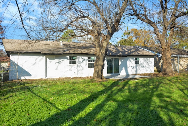 rear view of house featuring a yard