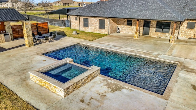 view of swimming pool with an in ground hot tub, exterior kitchen, and a patio