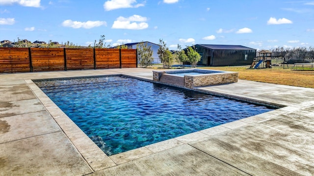 view of pool featuring a playground, an in ground hot tub, and a patio