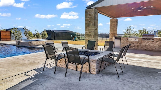 view of patio with a pool with hot tub, a playground, area for grilling, an outdoor fire pit, and exterior kitchen