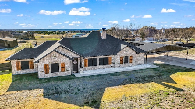 back of house featuring a carport and a yard