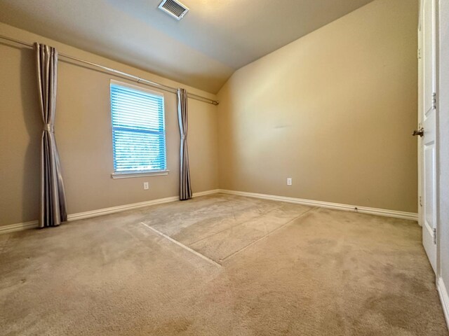 spare room with carpet floors and vaulted ceiling