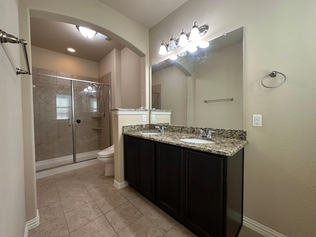 bathroom featuring tile patterned floors, a shower with door, vanity, and toilet